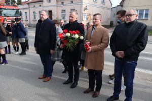 Dyrektorzy szkół składają kwiaty przed tablicą upamiatniejącą każń żołnierzy wyklętych