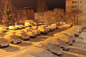 Zaśnieżone auta stoją na parkingu